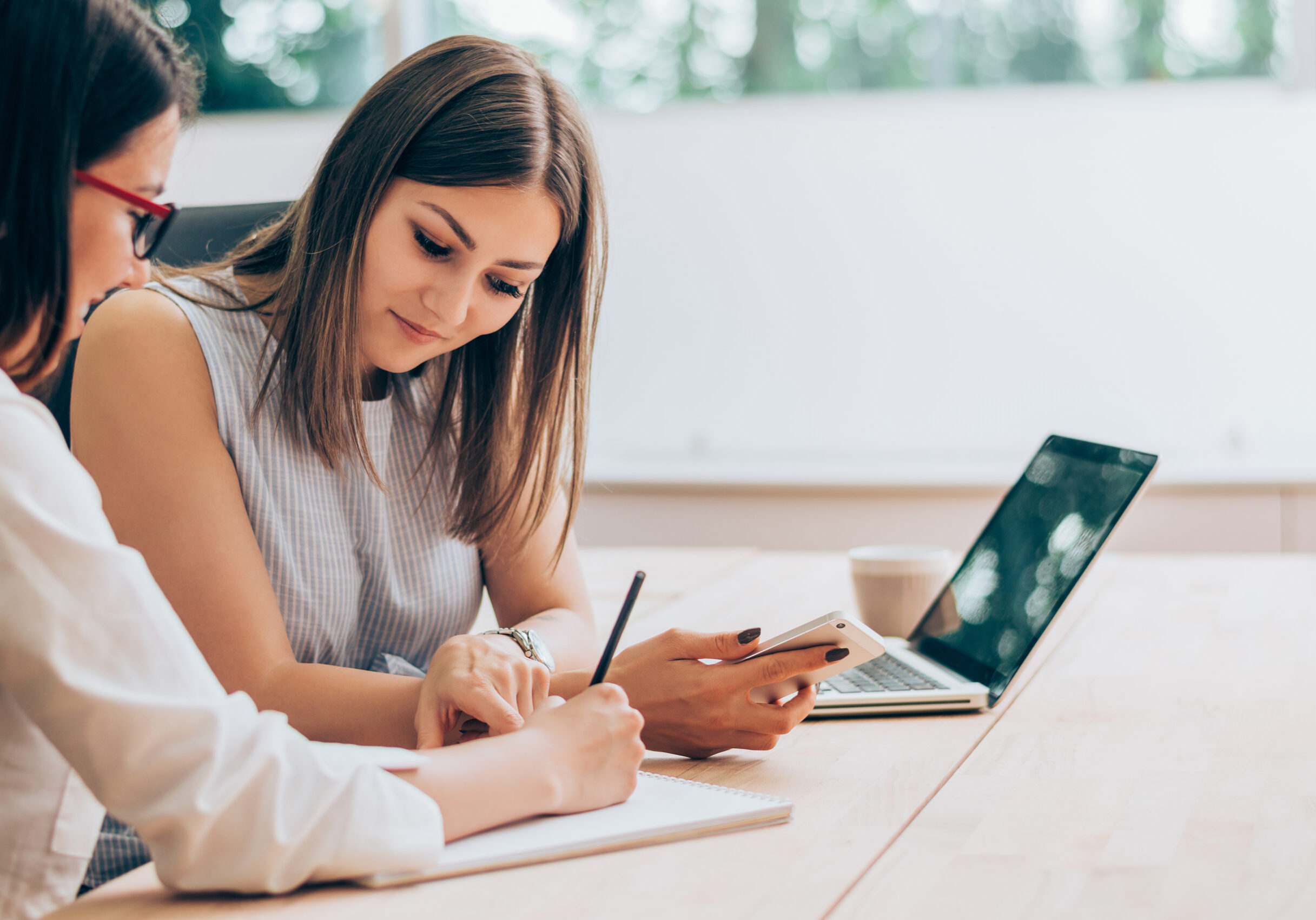 Two female colleagues in office working together.